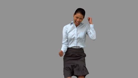 Cheerful-businesswoman-gesturing-on-grey-screen-