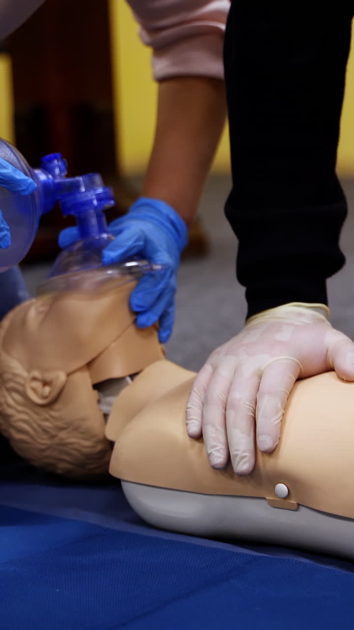 Training practice on a dummy. Students study doing resuscitation technique on a mannequin to save life. Cardiopulmonary resuscitation. Vertical video