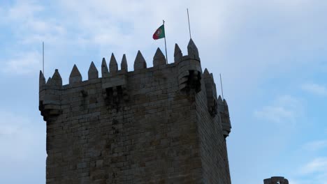 red and green flag waves strong and proud in wind on tower at chaves vila real portugal