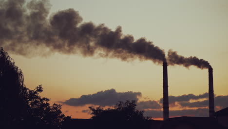 air pollution. industrial pipes with thick smoke pollute the atmosphere. two big pipes with toxic smoke on the natural background in the evening.