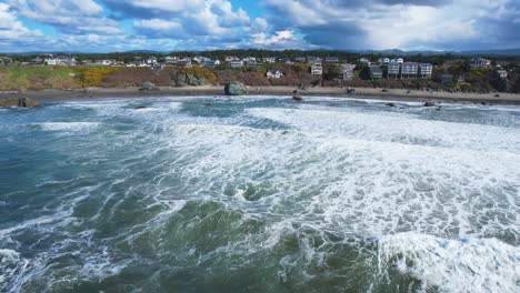 Stunning-4K-aerial-drone-shots-of-ocean-shore-waves-overseeing-houses-and-landscape-in-Bandon,-Oregon