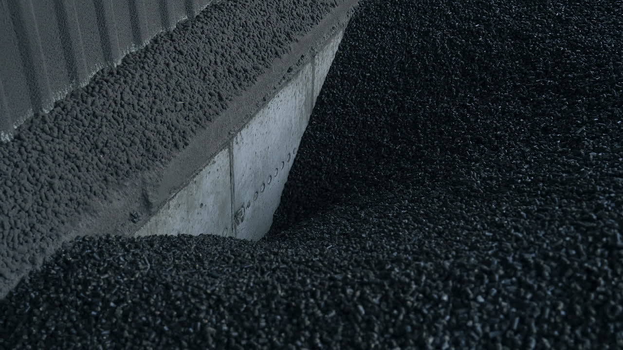 Charcoal storage at the agricultural grain elevator. Black charcoal pieces go down to the hearth to heat the grain storage. Close up.