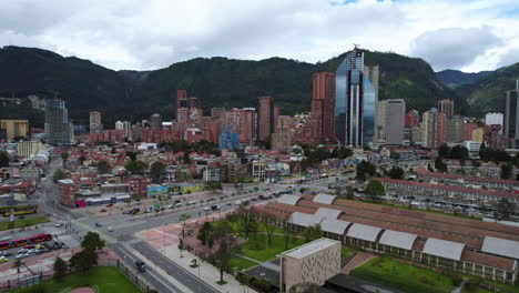 Aerial-tracking-shot-of-traffic-in-front-of-the-Bogota-city-skyline,-in-Colombia