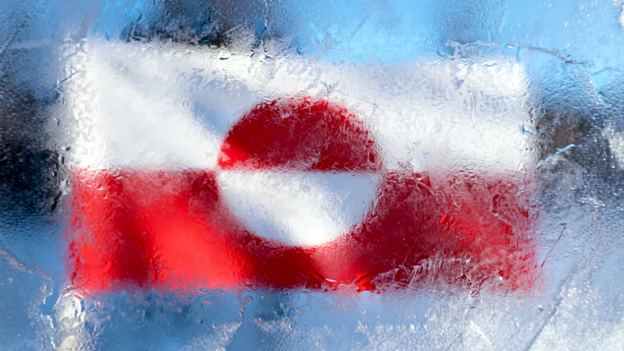 Verschiebender Frost auf einer gefrorenen Panel, die eine rot-weiße Flagge im kalten Freien zeigt, Sonnenlicht klärt die Sicht