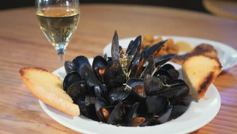 a plate of steamed mussels and a glass of white wine, slider hd