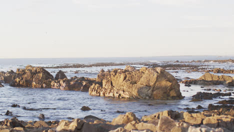 Vista-Del-Paisaje-Con-Rocas-Cerca-Del-Mar-Y-El-Cielo-Azul