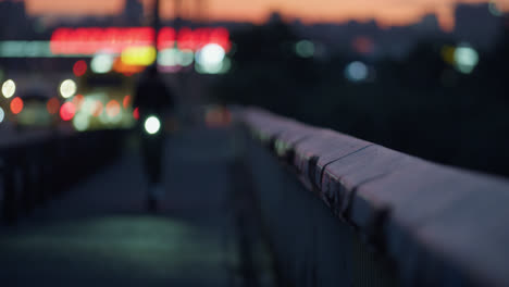 blurred bokeh taillights blinking. closeup grungy handrail reflecting headlights