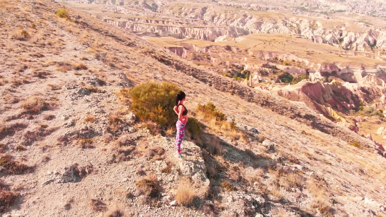 медленное движение - концепция успеха - в форме уверенная в себе женщина стоит победоносно празднуя достижение вершины горы. модель женщины стоит на вершине горы в позе поклонения