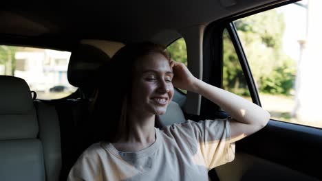 Young-woman-sitting-in-car-passenger-seat-looking-out-window,-enjoying-ride
