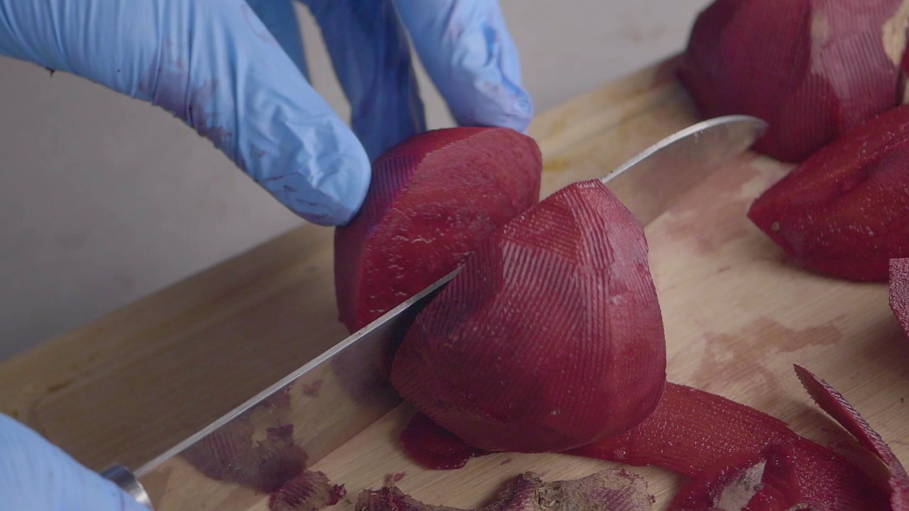 Close-up of Hands in Blue Gloves Slicing Beetroot