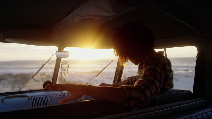 Man relaxing in camper van at beach 4k