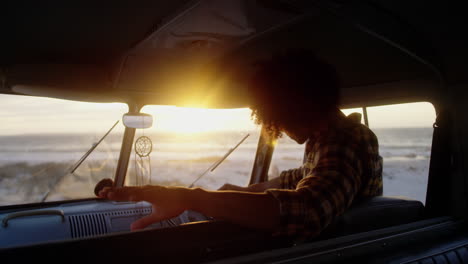 man relaxing in camper van at beach 4k