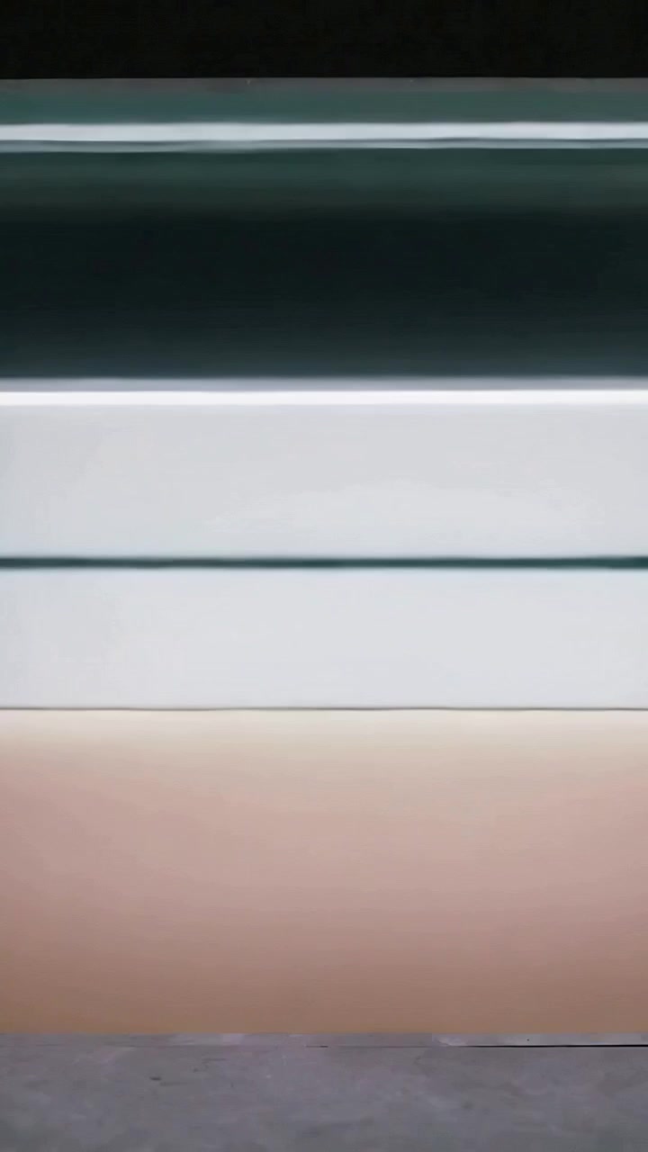 Vertical video: Shifting panel bands sliding down, shifting hue with frame shifts on wall baseboard