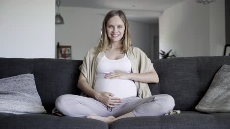 front view of pregnant woman massaging belly