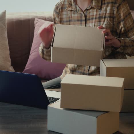 the owner of an online store working at home checks boxes with shipments