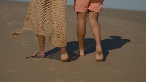 una pareja linda caminando por la playa.