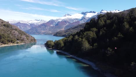 top aerial drone panoramic view beautiful mountains landscape and a cristal clear river along gravel road carretera austral in southern patagonia, chile