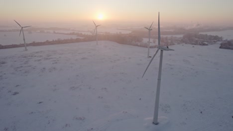 Un-Molino-De-Viento-Giratorio-Como-Generador-De-Energía-Se-Encuentra-En-El-Norte-De-Alemania-Cerca-De-La-Autopista-A1,-Paisaje-Nevado-Al-Atardecer