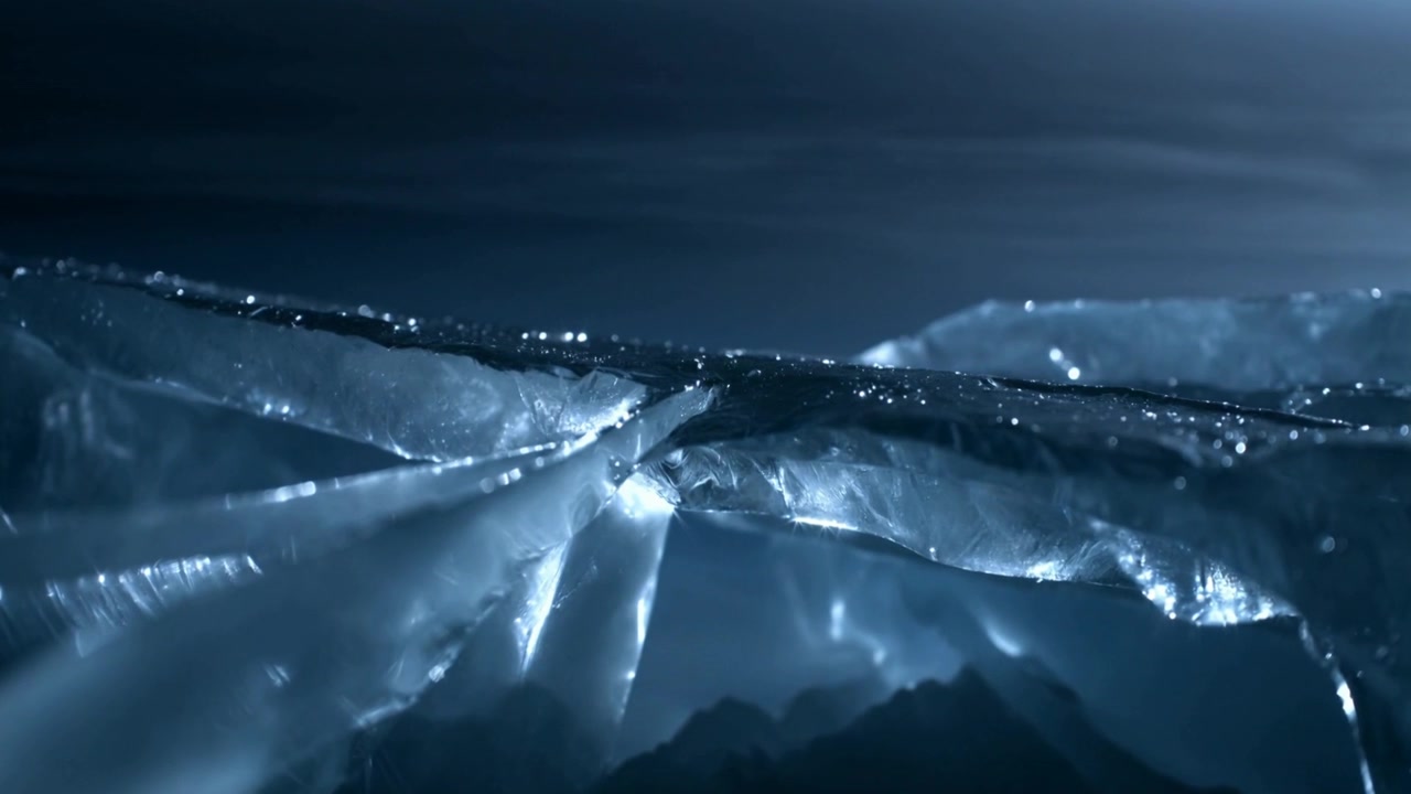 Catching cool light, translucent ice ridge showing glints, crevices at low view with distant peaks