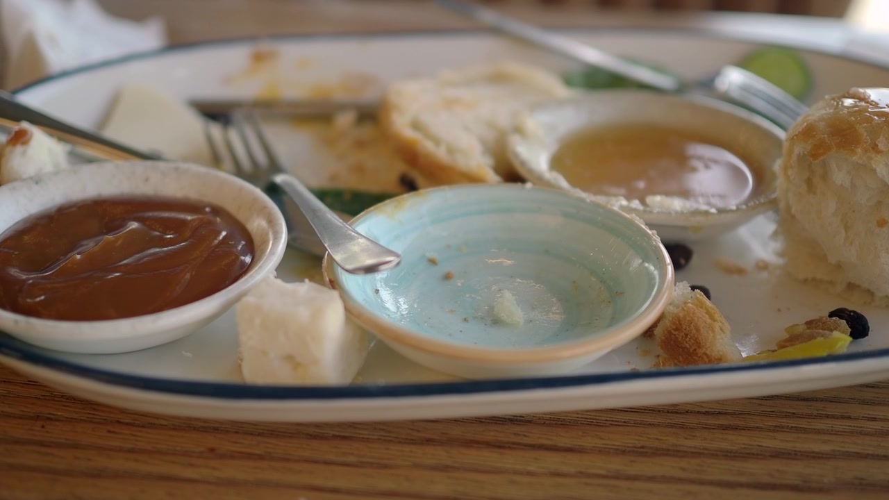 Plato de desayuno con restos, con pan y untables