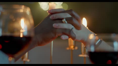 interracial couple holding hands at romantic dinner