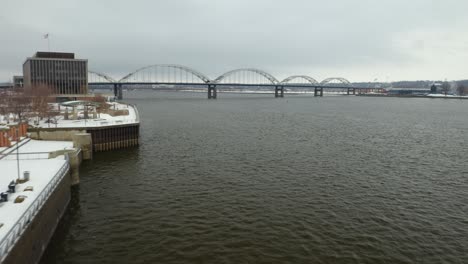 drone flies toward centennial bridge in winter, connecting illinois and iowa along the mississippi river
