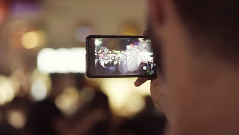 person shooting street event at night with a phone