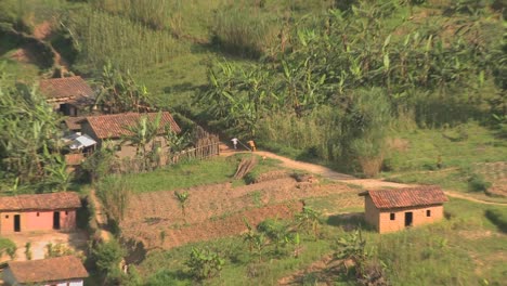 zoom out from villagers and farmers to reveal the steep and luxurious terrace farms of rwanda