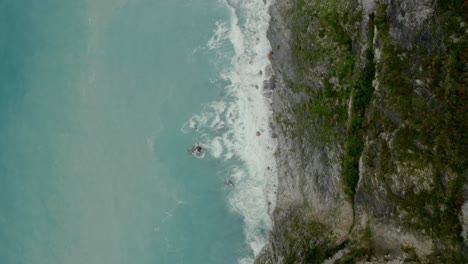 Vista-Aérea-De-Pájaro-Con-Vistas-A-La-Roca-Del-Borde-Del-Acantilado---Rompiendo-Las-Olas-Del-Océano-Costero-Salpicando-Contra-La-Costa-Rocosa