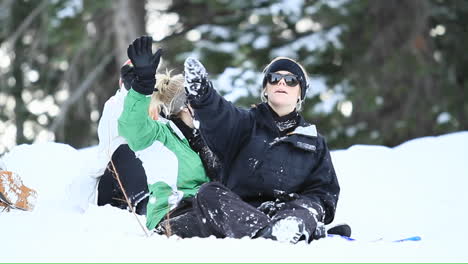 young women in the snow wave to skiers