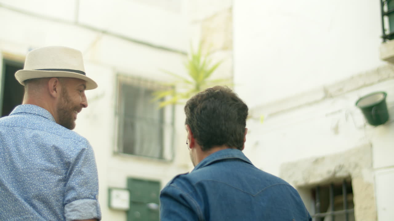 vista trasera de una pareja homosexual masculina subiendo escaleras