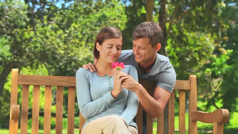 charming young man giving his girlfriend a flower