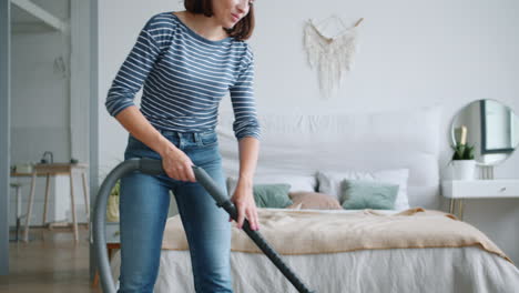 Woman Vacuuming a Bedroom