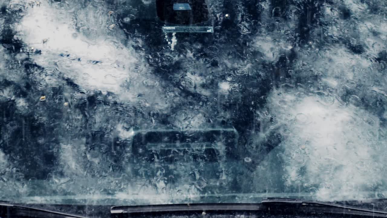 비는 리이 있는 박동으로 떨어지고, 앞 유리창에는 물이 가득한 시트가 있습니다.