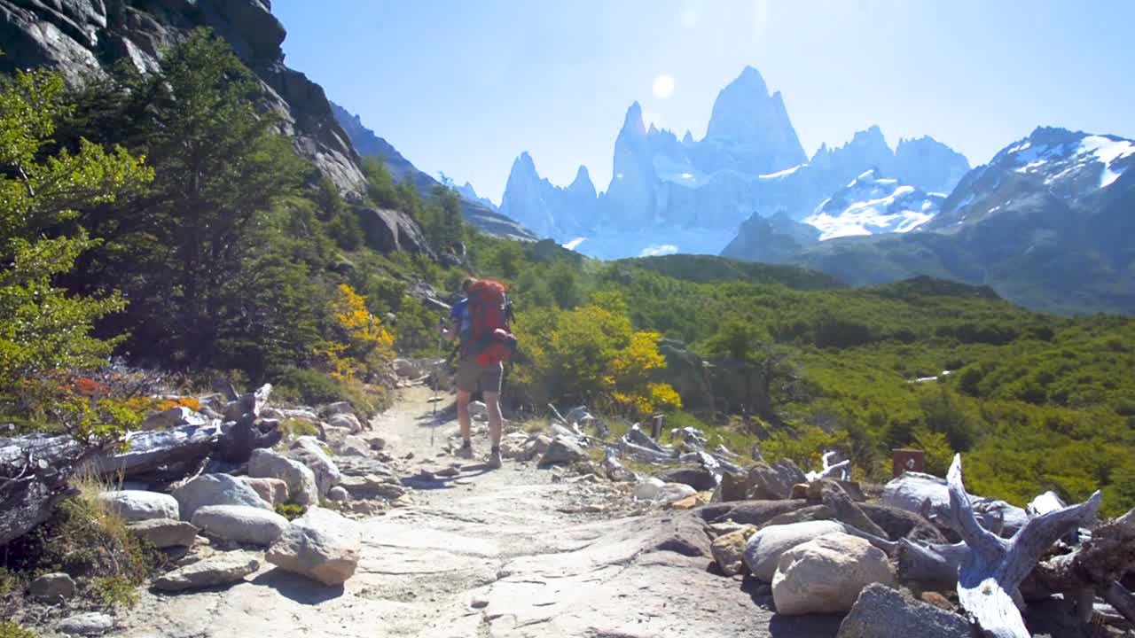 "Young woman wearing backpack hiking on a trail in Patagonia, Argentina