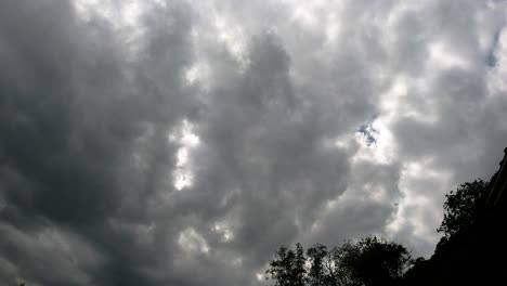 fast timelapse with dark dynamic clouds swirling with sun flare peeking through