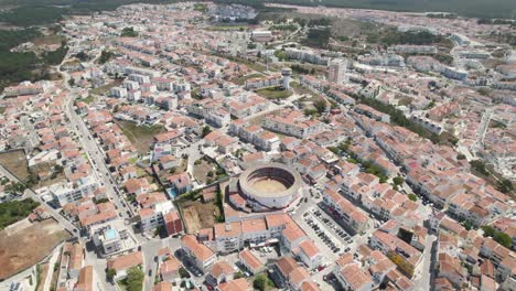 La-Inclinación-Aérea-Sobre-La-Plaza-De-Toros-Rodeada-De-Casas-Residenciales-Revela-El-Paisaje-Urbano-De-Nazaré