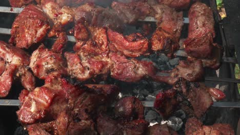 cooking pieces of pork meat on barbecue at lunch outdoors