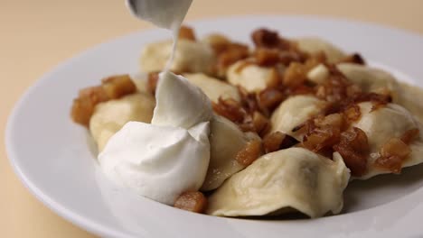 pierogi con crema agria y cebollas caramelizadas