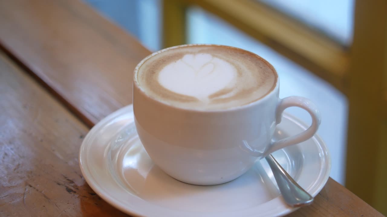Cappuccino in a white cup on a wooden table