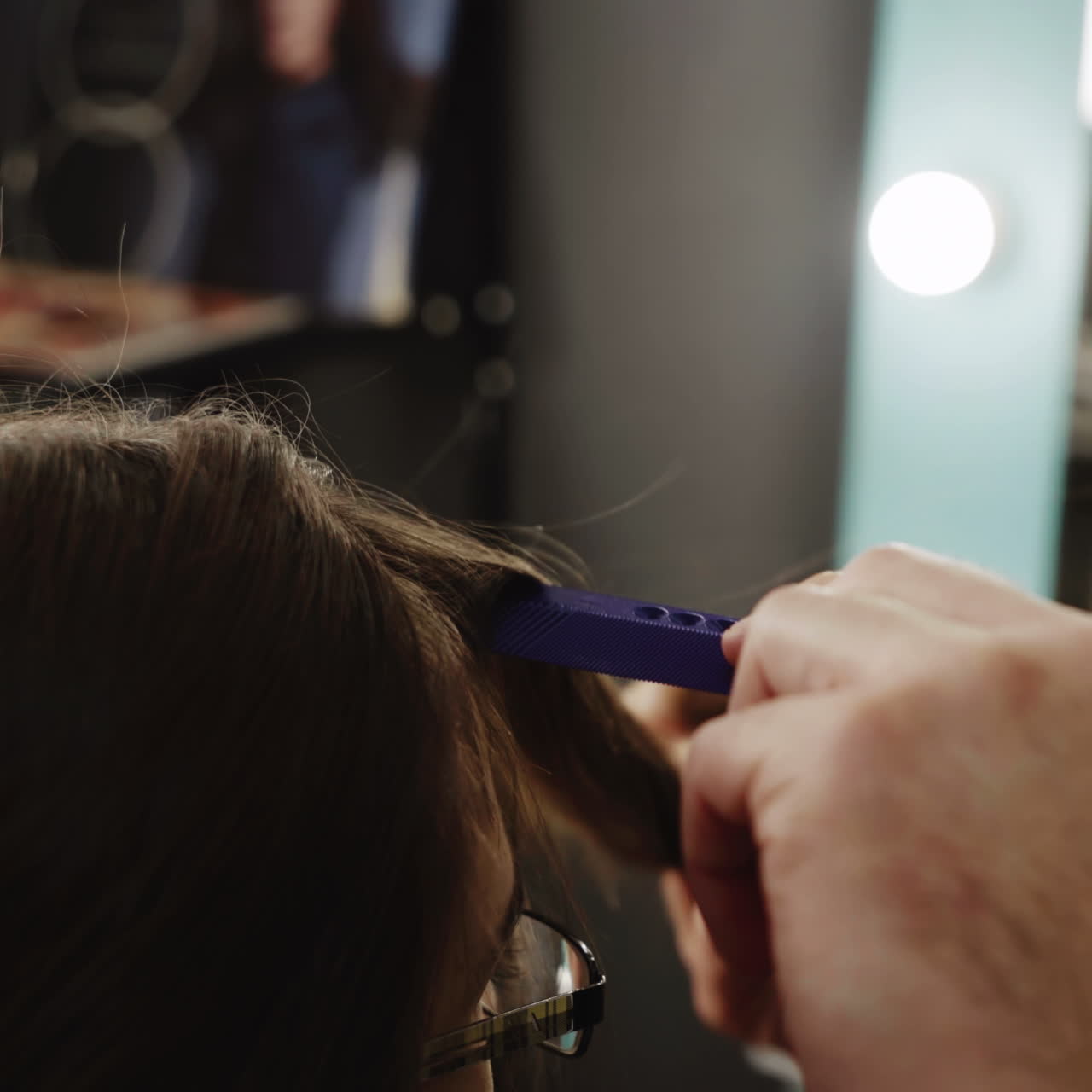 Hairdresser cutting and modeling brown hair by scissors and comb. Beauty industry concept Square video