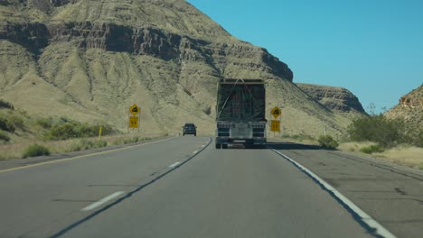 pov driving behind large truck along highway in nevada