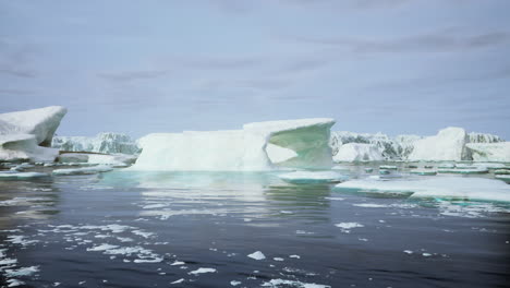 a view of a frozen lake with icebergs and glaciers in the background