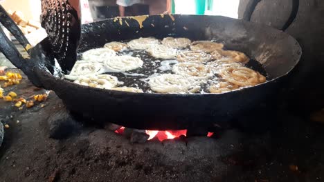 jalebi sweet making in a frying pan.