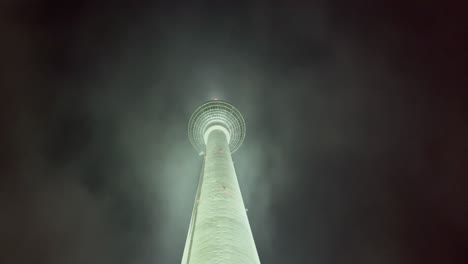 berlin tv tower with dark sky at night and dramatic clouds, germany