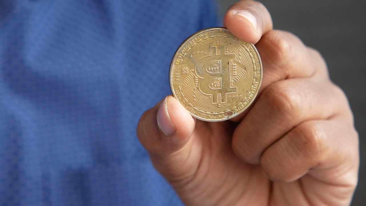 la mano que sostiene un bitcoin