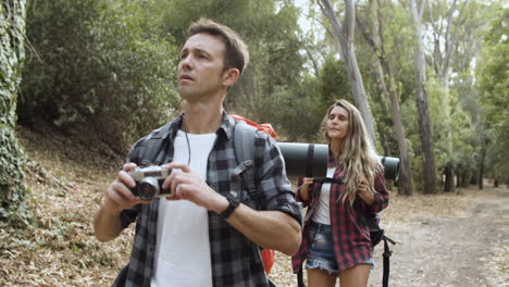 casal de caminhantes com câmera fotográfica tirando fotos da paisagem