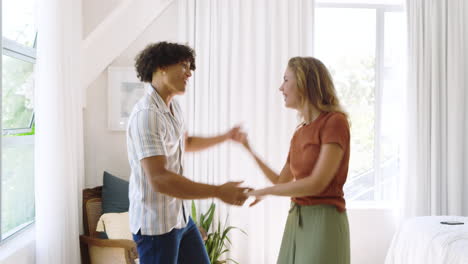 dancing joyfully at home, diverse couple sharing lively moment together