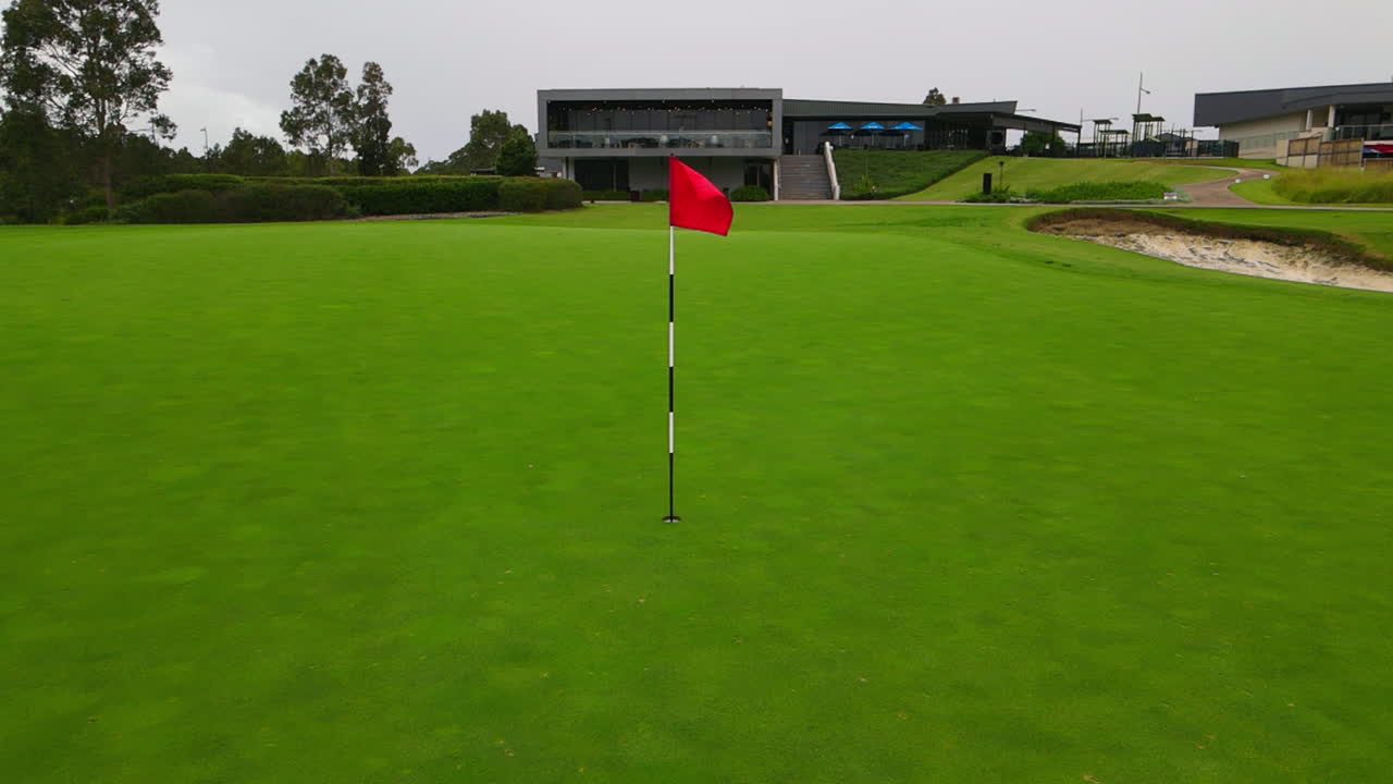 골프 코스 정적인 전망에서 잘 손질된 녹색에 있는 빨간색 골프 폴 플래그