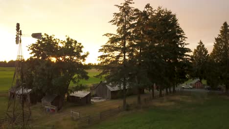 aerial of a windpump on a farm house property during a sunset